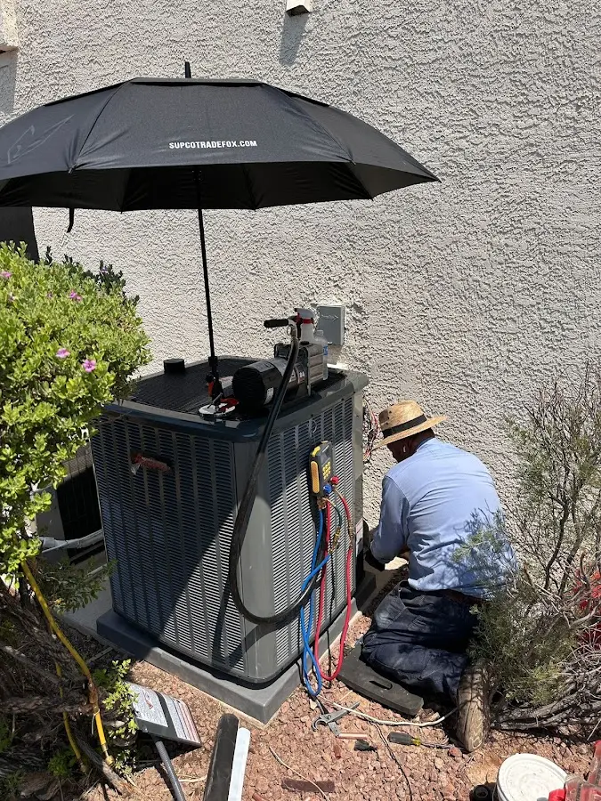 HVAC technician performing outdoor AC maintenance in Fort Valley