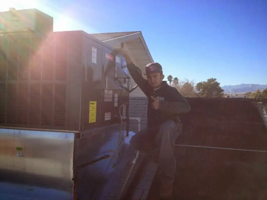 HVAC technician performing Heat Pump Repair on a rooftop unit in Fort Valley